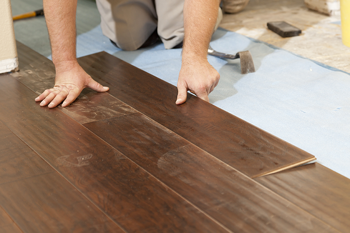 Man Laying Hardwood Flooring in a home